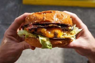 Un burger appétissant tenu dans les mains d'une personne